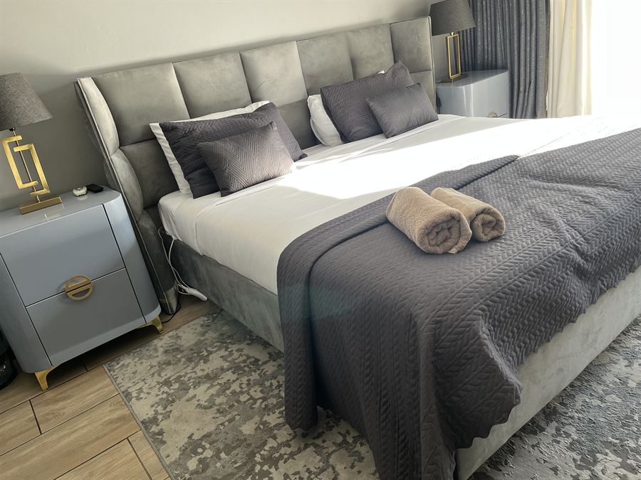 King bed with upholstered headboard in the Executive Room at Cozy Corner Brandwag