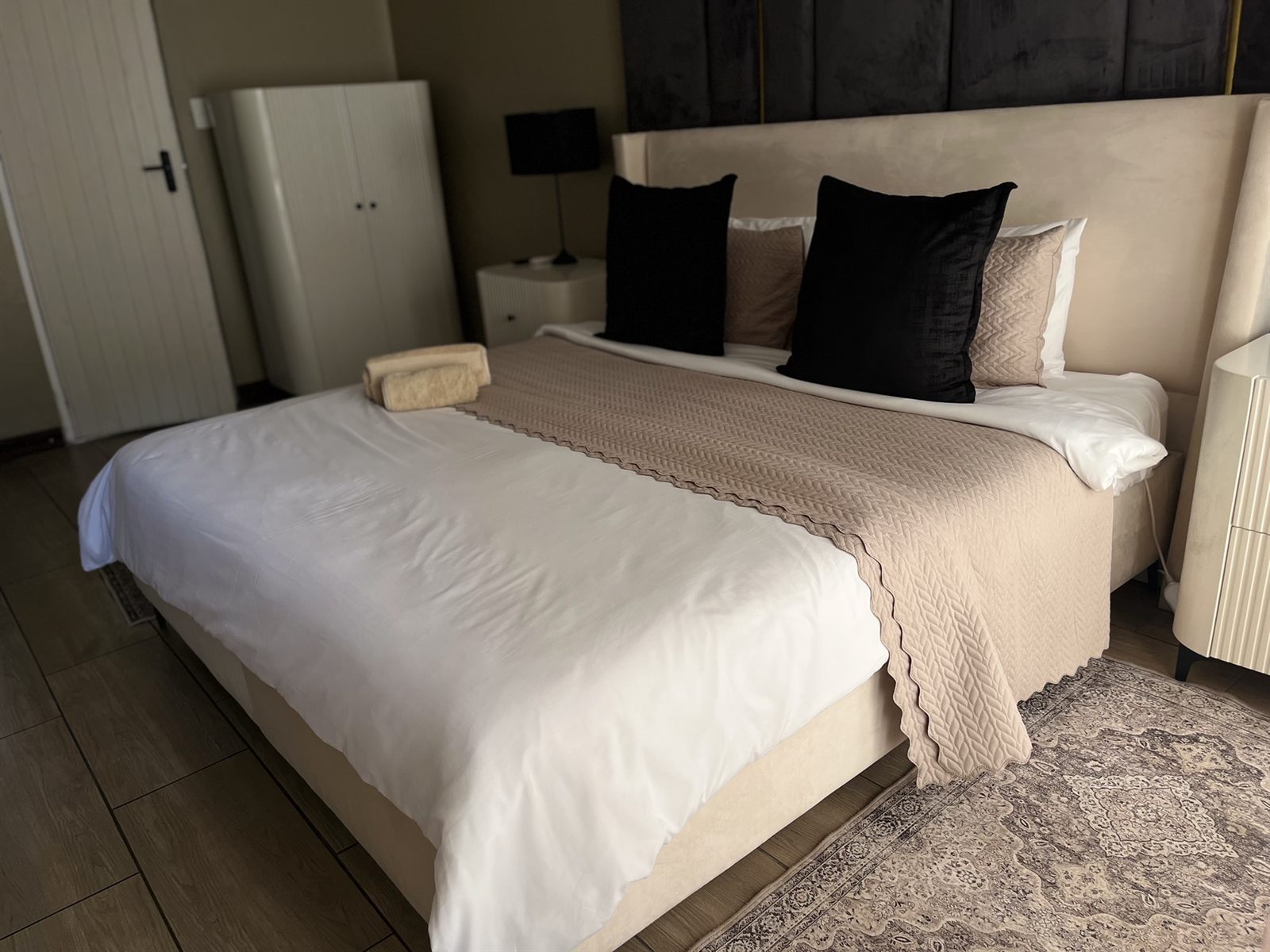 Executive Room bed with scatter cushions and wardrobe at Cozy Corner Brandwag