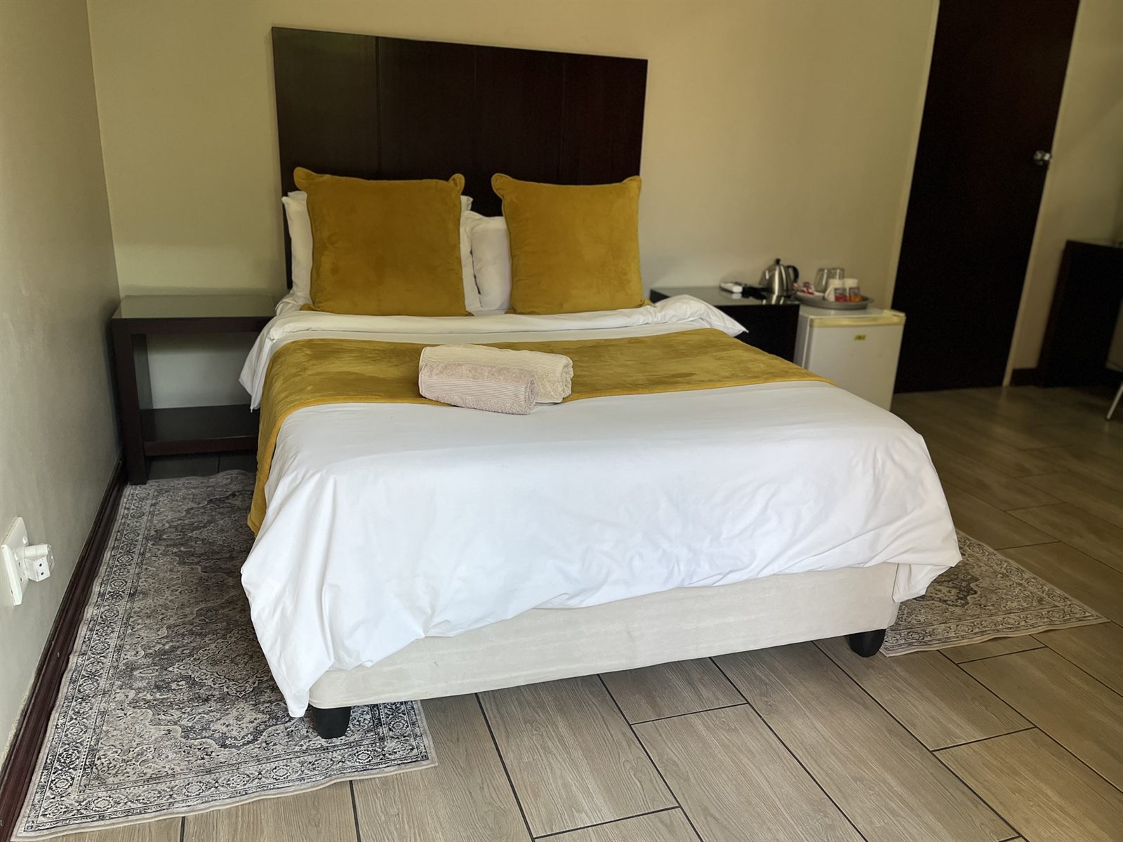 Standard Double Room bed with bar fridge and tea and coffee station at Cozy Corner Brandwag