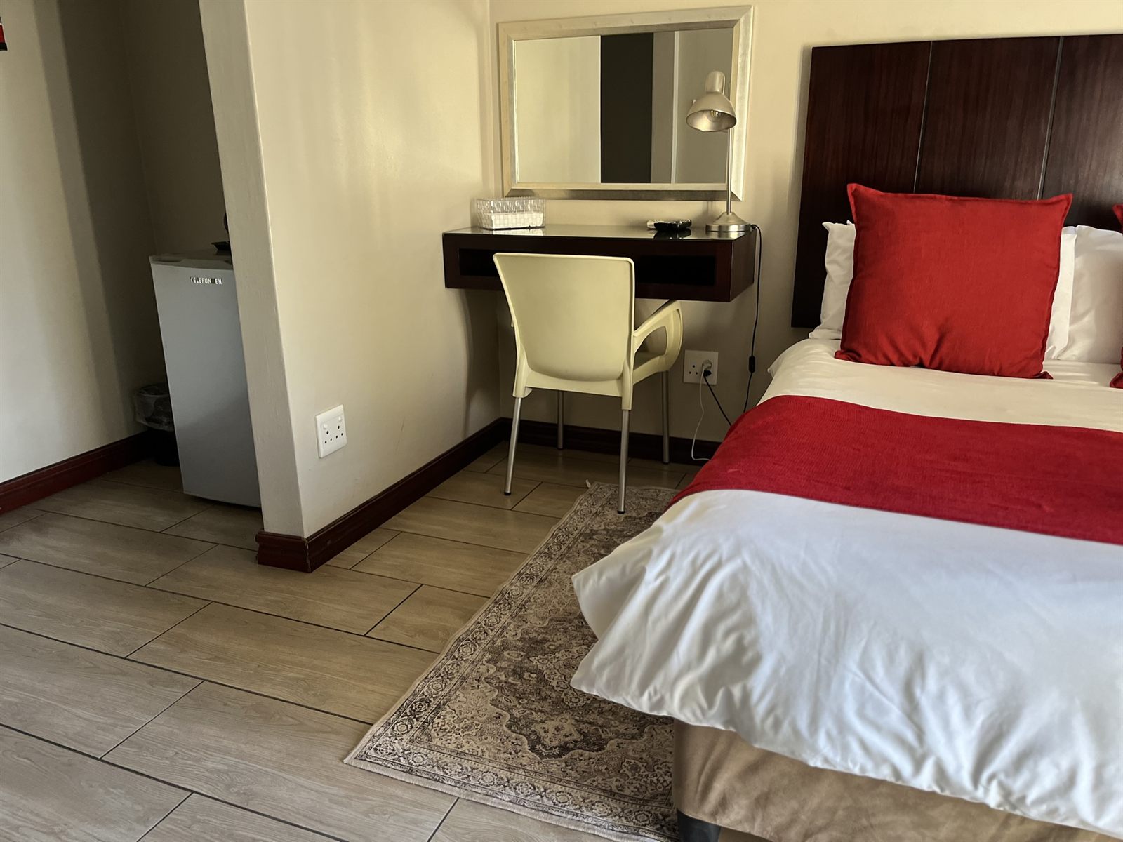 Standard Double Room desk, mirror and bar fridge at Cozy Corner Brandwag
