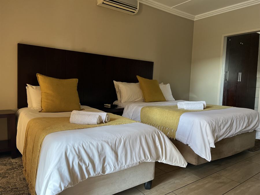 Two beds with gold throws in the Standard Family Room at Cozy Corner Brandwag