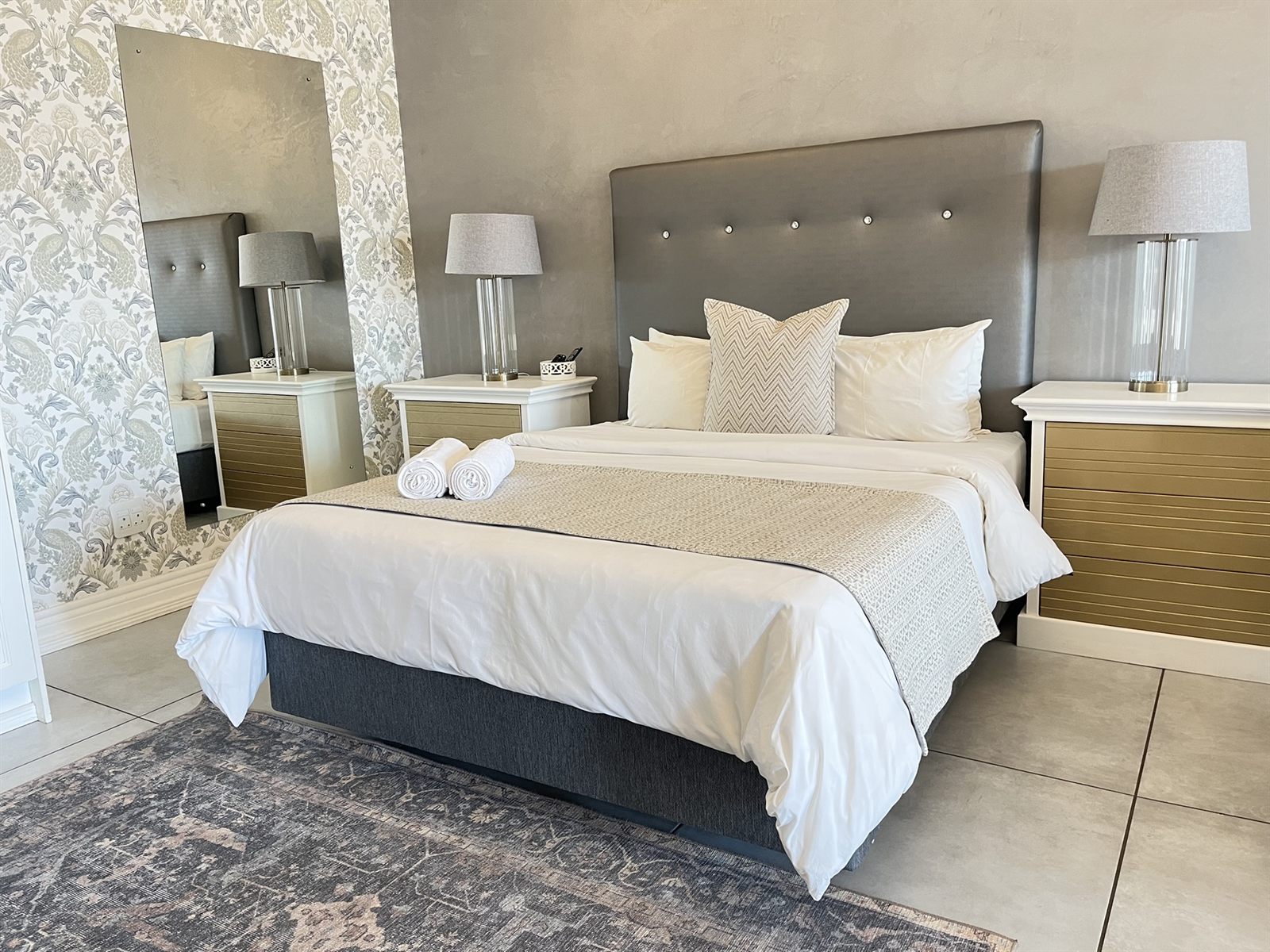 Queen bed against a damask feature wall in the Executive Queen Room at 2nd Cozy Corner Woodland Hills